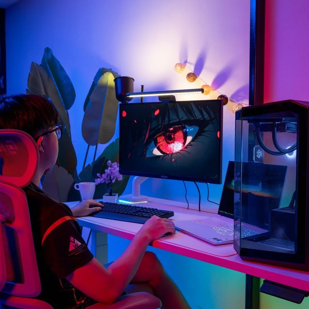 Person using an Interdesk workstation with an ergonomic chair, RGB lighting, monitor, laptop and gaming PC